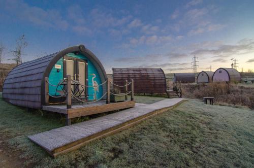 a small dome house with a wooden walkway in a field at Rossendale Holiday Cottages & Spa in Rossendale