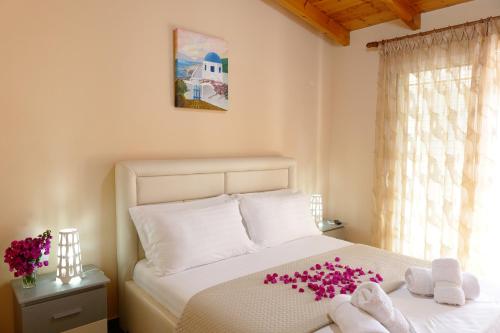 Un dormitorio con una cama con flores rosas. en Vila Cerca de Mar, en Ksamil