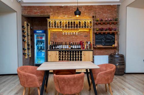 a table and chairs in a bar with wine bottles at Hotello in Tbilisi City