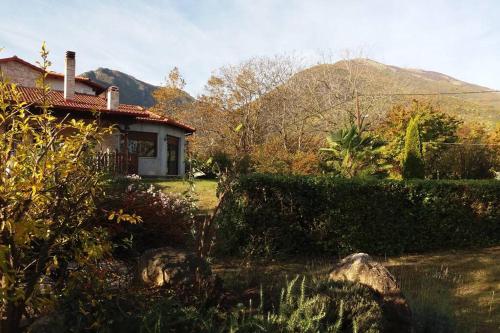 una casa en un patio con una montaña en el fondo en Elegance in the Nature, en Agios Nikolaos