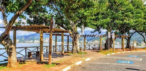 a wooden pavilion next to a body of water at POUSADA VERDE in Caraguatatuba