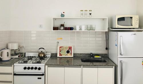 cocina con electrodomésticos blancos y nevera blanca en Departamento en Olavarría en Olavarría