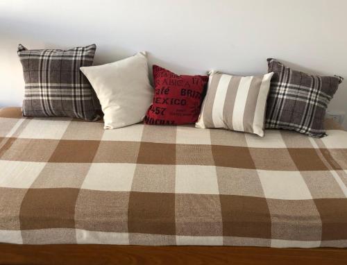 a bed with four pillows on top of it at Departamento en Olavarría in Olavarría