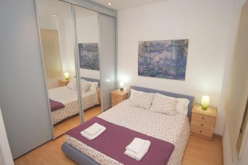 バルセロナにあるLovely Apartment at Park Güellのベッドルーム1室(ベッド2台、鏡付)