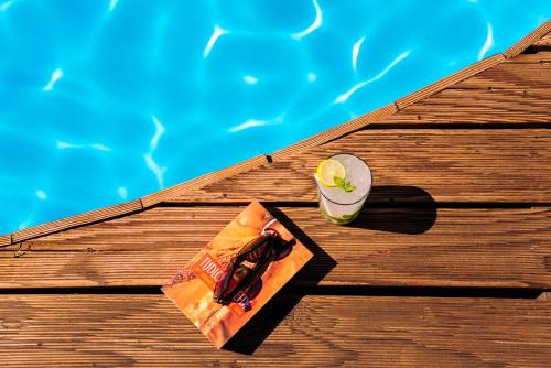 帕羅奇亞的住宿－卡薩蒂羅姆酒店，坐在游泳池旁的桌子上喝一杯