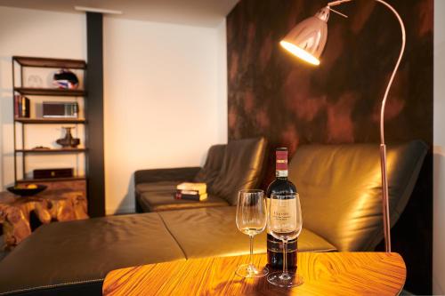 uma garrafa de vinho e dois copos numa mesa em City Apartments Hannover em Hanôver