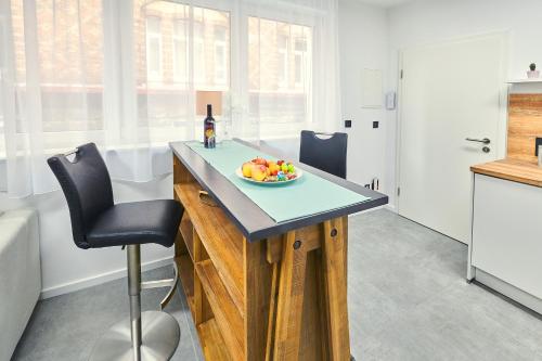 a kitchen with a table with a bowl of fruit on it at City Apartments Hannover in Hannover