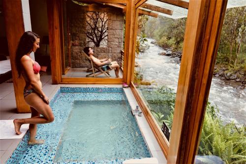 a man and a woman in a room with a swimming pool at Saguamby Mindo Lodge in Mindo
