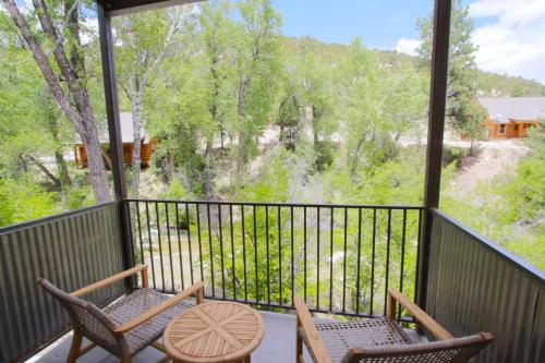 a patio area with a table, chairs, and a balcony at Mount Princeton Hot Springs Resort in Buena Vista