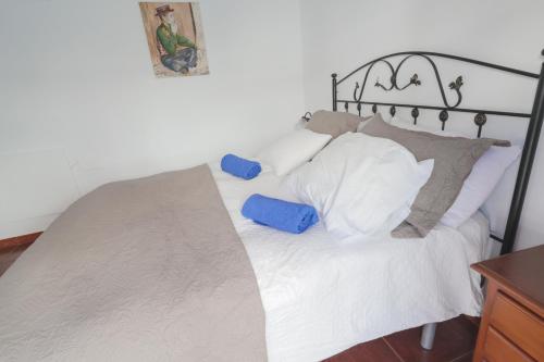Un dormitorio con una cama con almohadas blancas y un marco negro. en Casa Hadriano, en Cómpeta
