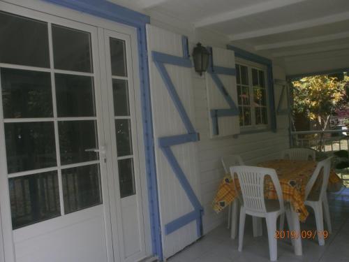 a porch with a table and chairs and a door at case créole in Pointe-Noire