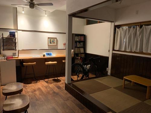 a room with a desk and stools in a room at Kakunodate Guest House Choux in Senboku