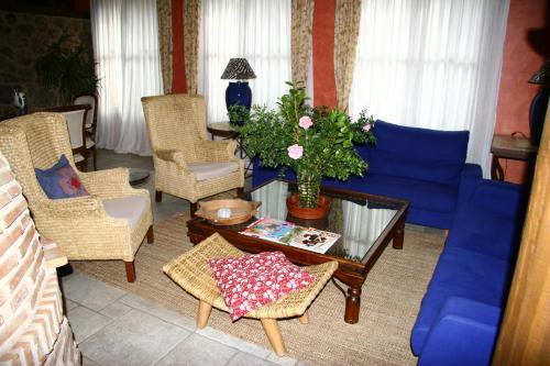 a living room with a blue couch and chairs at Hotel Rural Peña Del Alba in Arroyomolinos de la Vera