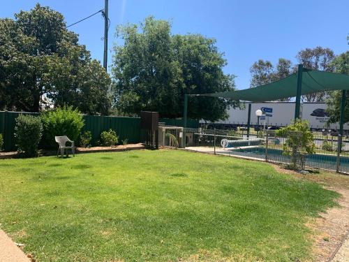 a yard with a fence and a pool at Jerilderie Motor Inn in Jerilderie