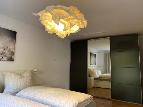 a bedroom with a bed and a chandelier at Wohne im Grünen/Innsbruck/4 Pax in Innsbruck