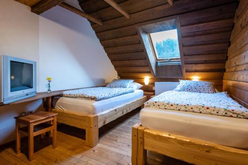 2 camas en una habitación con TV y TV en Penzion pod Lipou, en Liptovský Ján