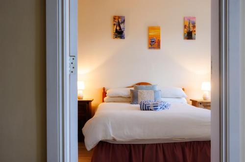 a bedroom with a bed with white sheets and pillows at The Old Post Office in Renvyle