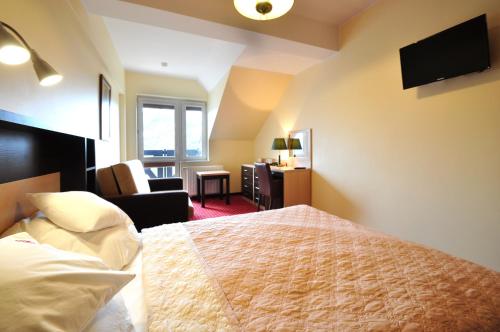 a hotel room with a bed and a living room at Hotel Continental in Krynica Morska