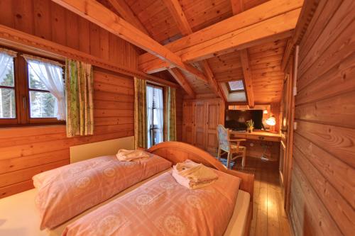 1 Schlafzimmer mit 2 Betten in einem Blockhaus in der Unterkunft Glocknerhaus in Berg im Drautal