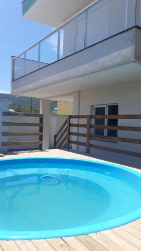 ボンビーニャスにあるSua casa fora de casaの家の前の青い大型スイミングプール