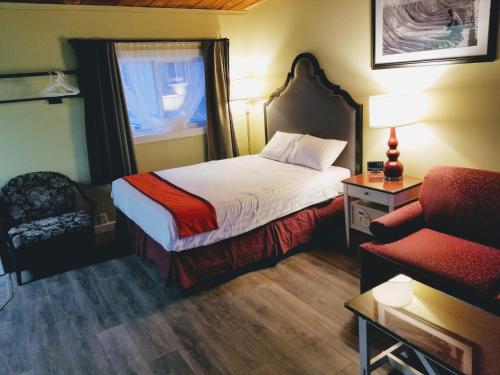 Habitación de hotel con cama y silla en Ace Motel, en Princeton