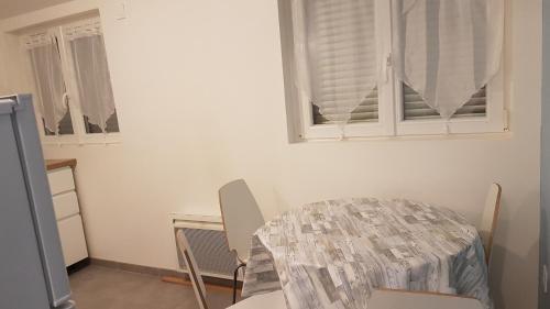 einen Tisch und Stühle in einem Zimmer mit Fenster in der Unterkunft Appartement au calme in Changis-sur-Marne