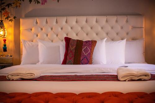 a bedroom with a white bed with white pillows at Home Garden Hotel in Cusco