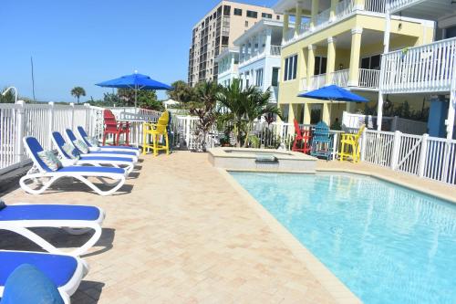 een zwembad met stoelen en parasols naast een gebouw bij Beachfront Bliss Villas in Clearwater Beach