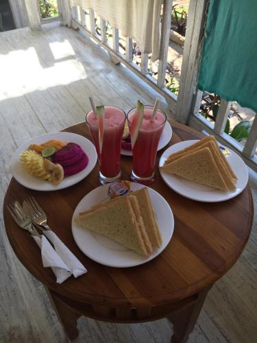 The Lucky Cottage في نوسا ليمبونغان: طاولة خشبية مع لوحات من السندويشات والمشروبات