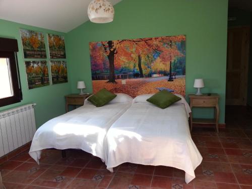 1 dormitorio con 1 cama blanca y una pintura en la pared en Hotel Rural La Casa del Tio Telesforo, en Trescasas