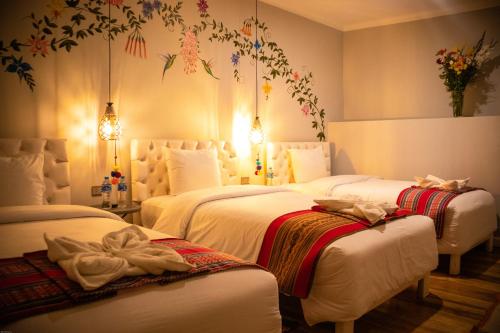 a bedroom with two beds with towels on them at Home Garden Hotel in Cusco