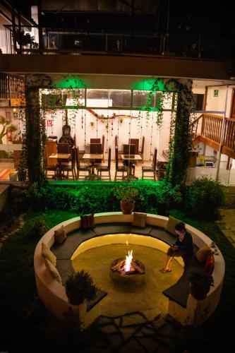 a man sitting around a fire pit in a courtyard at Home Garden Hotel in Cusco