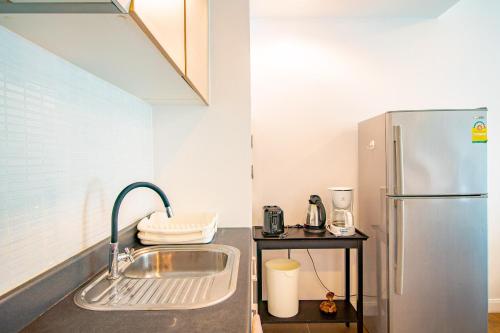 a kitchen with a sink and a refrigerator at Baan Sandao Condo in Hua Hin