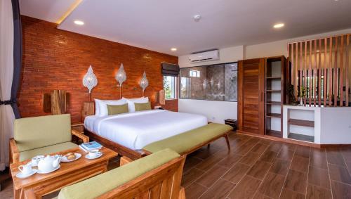 a bedroom with a bed and a table and chairs at Araya Angkor Residence in Siem Reap