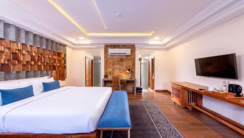 a bedroom with a large bed and a television at Araya Angkor Residence in Siem Reap