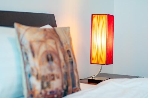 a red lamp sitting on a bed next to a pillow at Baan Sandao Condo in Hua Hin