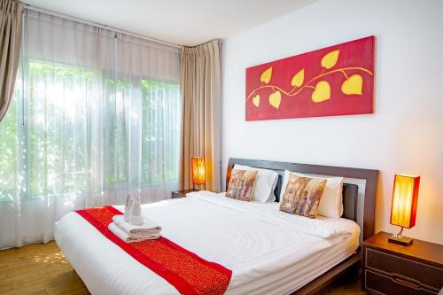 a bedroom with a large bed with a red blanket at Baan Sandao Condo in Hua Hin