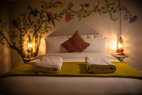 a bedroom with a bed with towels on it at Home Garden Hotel in Cusco