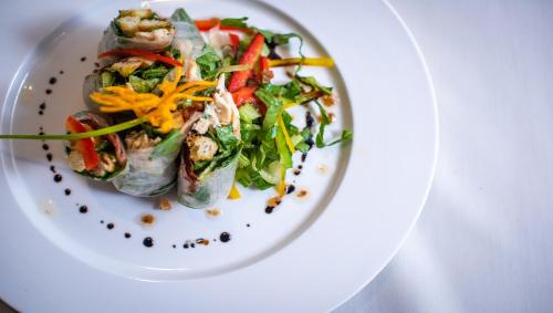 a white plate with a salad with shrimp and vegetables at Araya Angkor Residence in Siem Reap