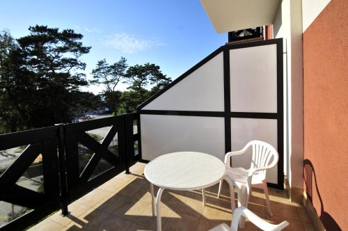 a white table and chairs on a balcony with a window at Hotel Continental in Krynica Morska