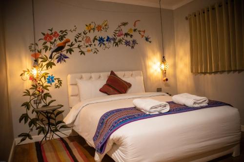 a bedroom with a bed with towels on it at Home Garden Hotel in Cusco