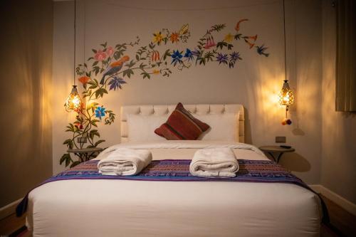 a bedroom with a bed with towels on it at Home Garden Hotel in Cusco