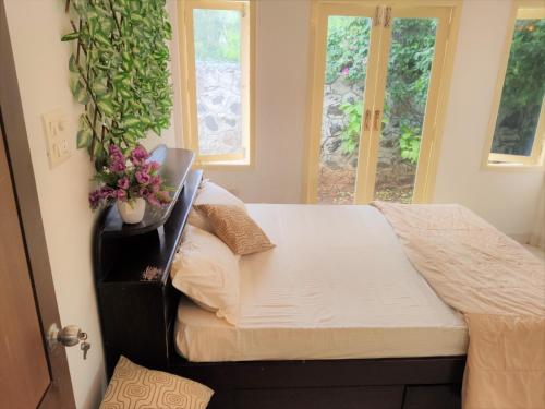 Private Luxury Beach Side Villa في تشيناي: غرفة نوم يوجد عليها سرير وزرع