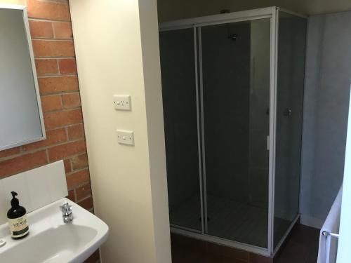 a glass shower in a bathroom with a sink at Dunolly Broadway B&B in Dunolly