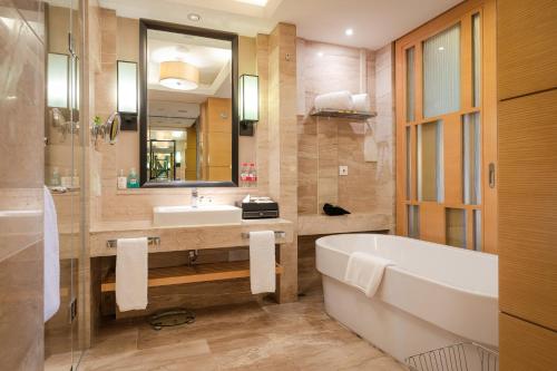 a bathroom with a tub and a sink and a bath tub at Your World International Conference Centre Hotel in Yiwu
