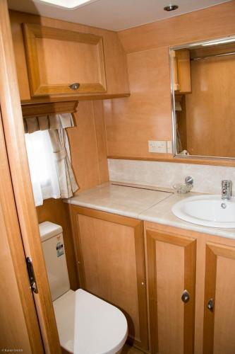 a small bathroom with a toilet and a sink at Longford Riverside Caravan Park in Longford