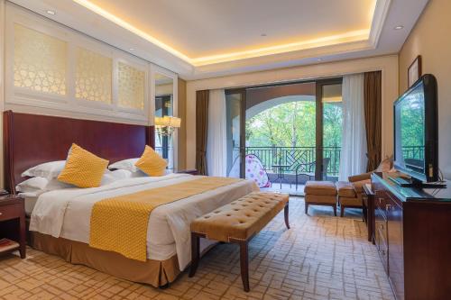 a bedroom with a bed and a television and a balcony at Your World International Conference Centre Hotel in Yiwu