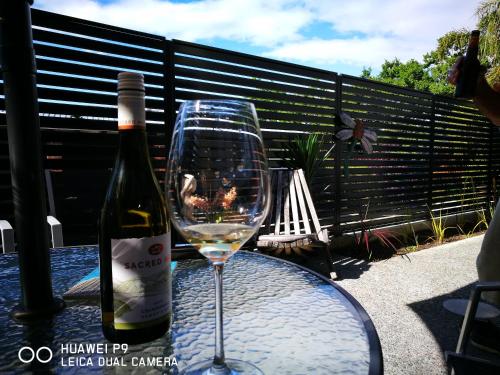 una bottiglia di vino e un bicchiere su un tavolo di CBD Grampians studio a Nelson