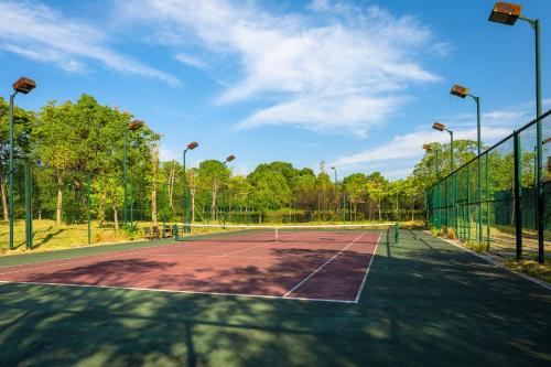 a tennis court with a net and trees on it at Your World International Conference Centre in Yiwu