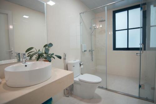uma casa de banho com um lavatório, um WC e um chuveiro em HOÀNG LONG HOTEL em Ha Long